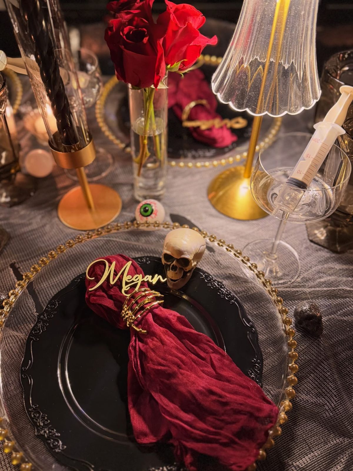 A place setting seen from above with a gold script name card tucked into the napkin ring.
