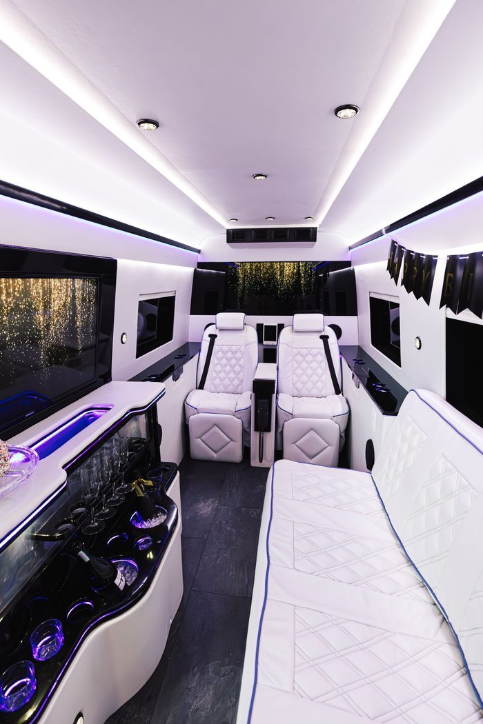 The Sprinter cabin set for a birthday with a banner hung along the wall and the bar stocked.